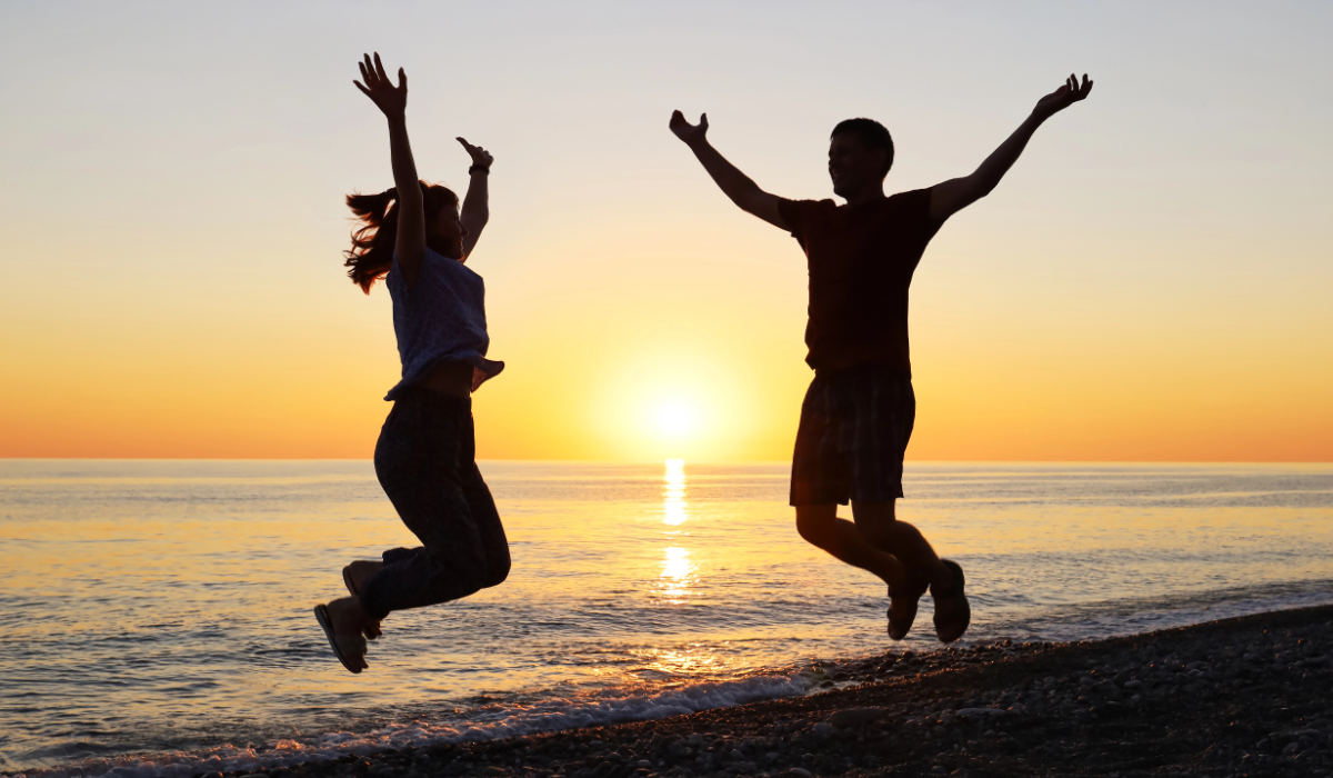 Couple jumping in the beach